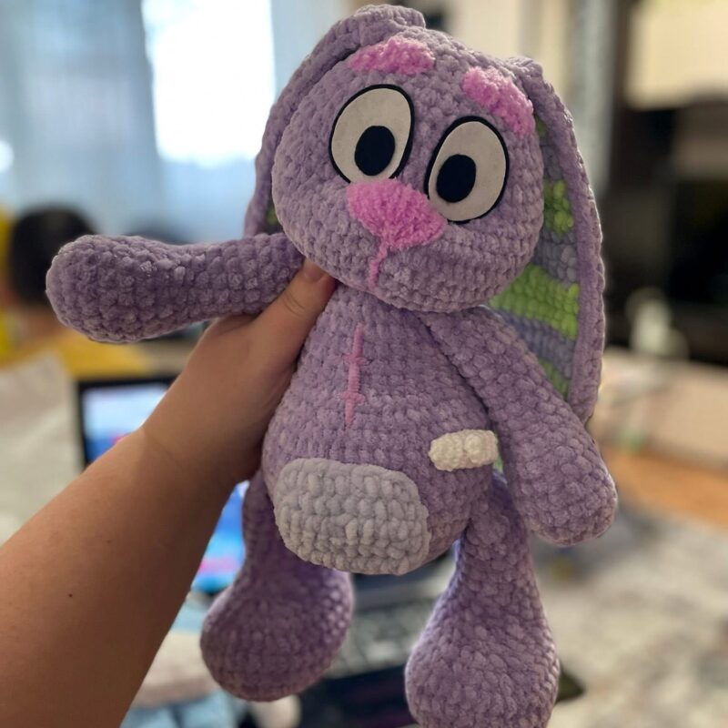 A soft stuffed rabbit with a scar after open-heart surgery and a button